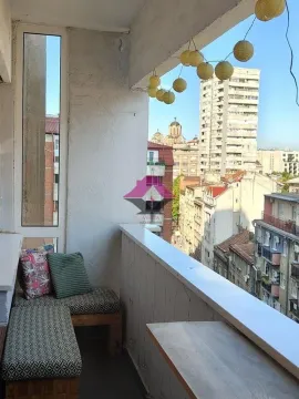 Small covered balcony with seating and city views. - image 15