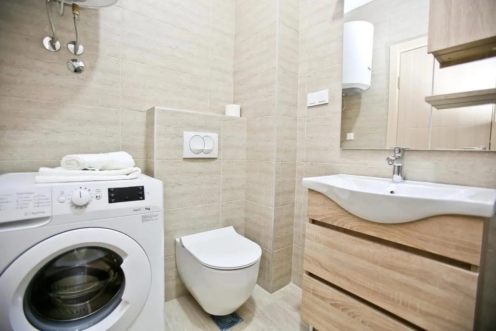Modern equipped bathroom with a washing machine and vanity sink.