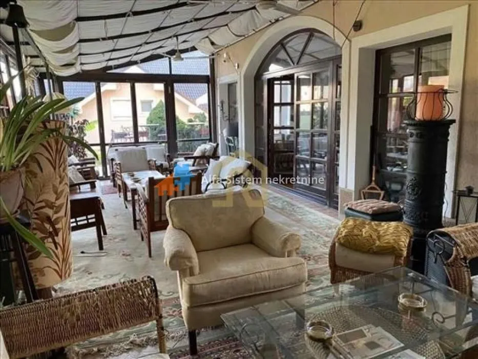 Enclosed terrace with seating furniture and a view of the surroundings.