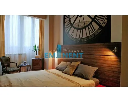Bedroom with a double bed and a decorative wall with a clock motif. - image 10