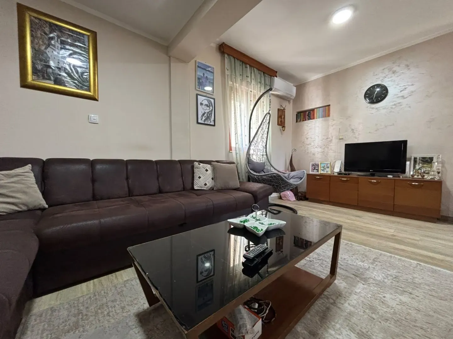 Spacious living room with a brown sectional sofa and television.