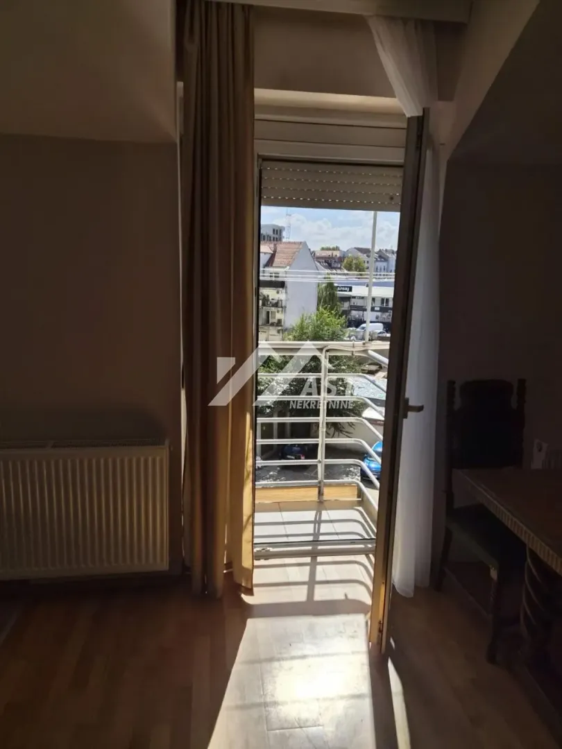 Izlaz na balkon sa pogledom na ulicu i gradsko okruženje.