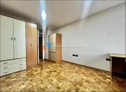 Nameštena spavaća soba sa drvenim ormarima i parketom na podu. - image 14