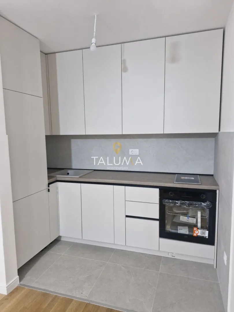 New kitchen with white cabinets and a built-in oven.