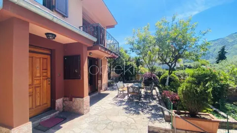 View of the house entrance and landscaped yard with seating furniture. - image 6