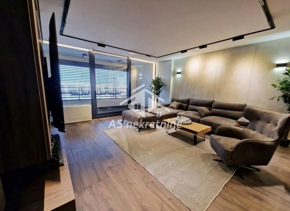 Modern living room with a sectional sofa, armchair, and access to the terrace.