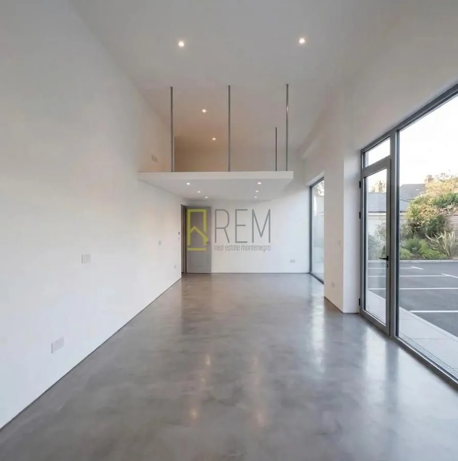 Empty living room with large windows and a gallery.