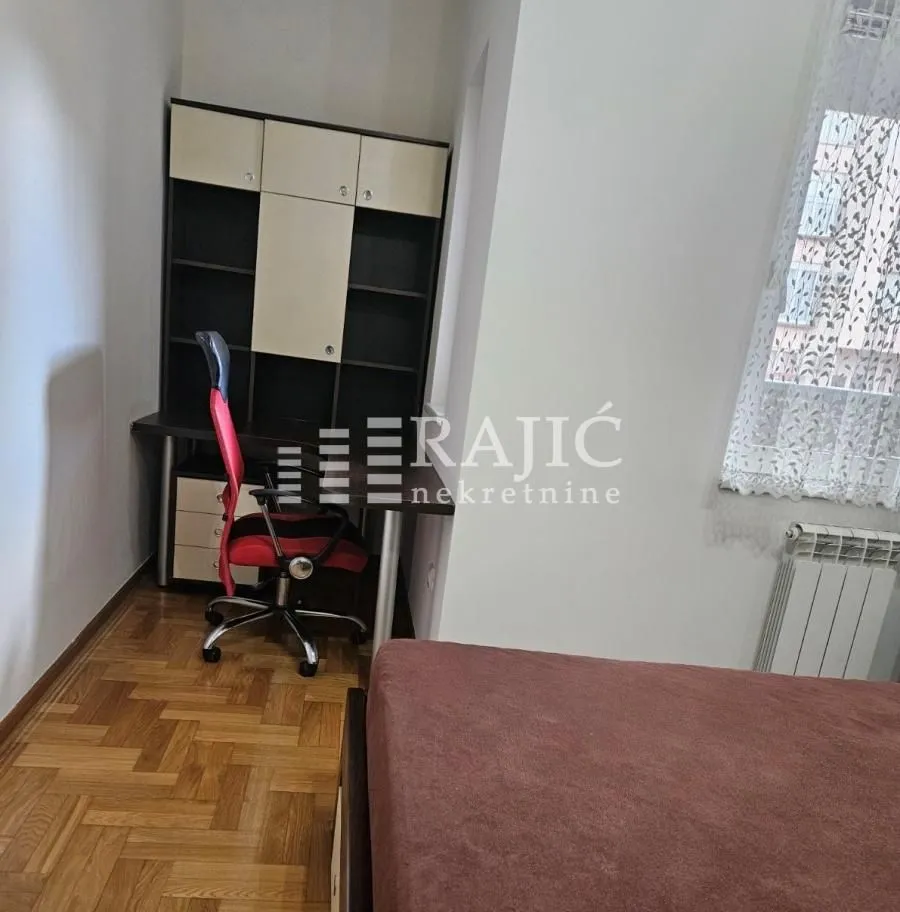Furnished bedroom with a desk and bed.