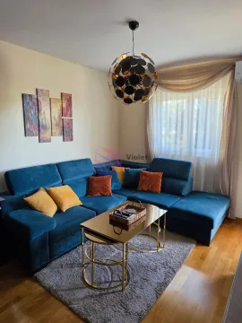 Dnevna soba sa plavom ugaonom garniturom, stočićem i modernim lusterom. - image 3