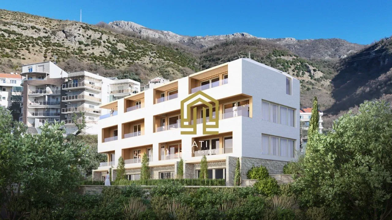 Spoljašnji izgled moderne stambene zgrade u izgradnji sa planinskim pejzažem u pozadini.