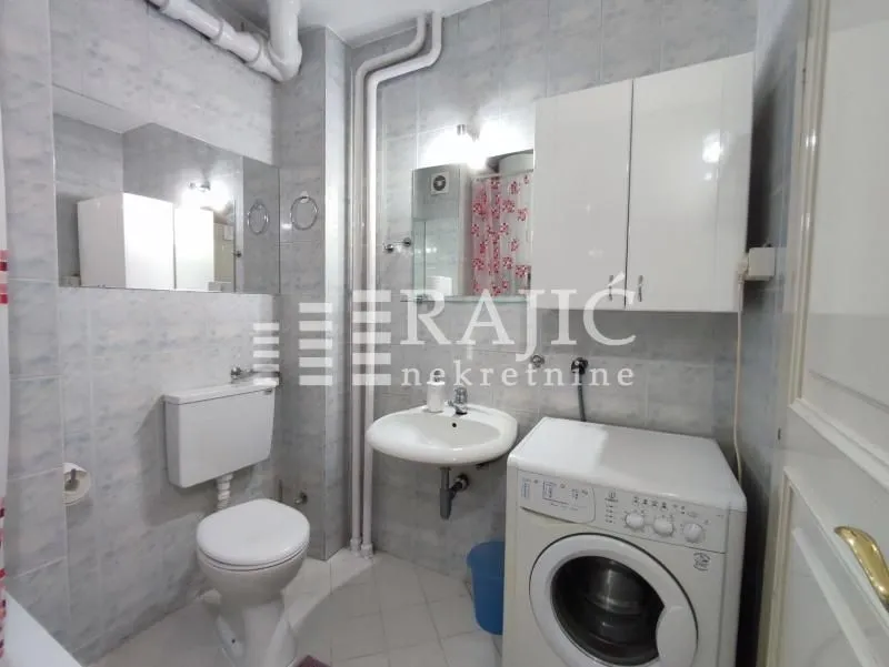 Smaller bathroom with sanitary fixtures and a washing machine.