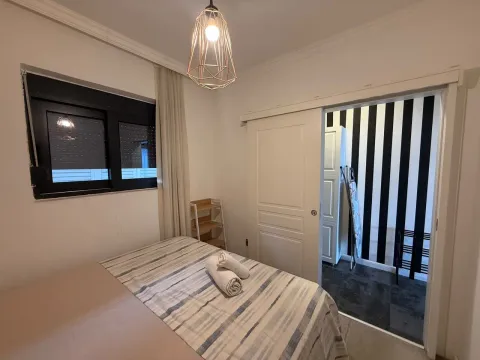 Uređena spavaća soba sa bračnim krevetom i pogledom na unutrašnju prostoriju. - image 17