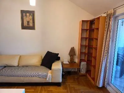 Living room with a sofa, shelving unit, and access to the terrace. - image 8