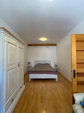 Spavaća soba sa bračnim krevetom, drvenim ormarom i laminatnim podom. - image 11