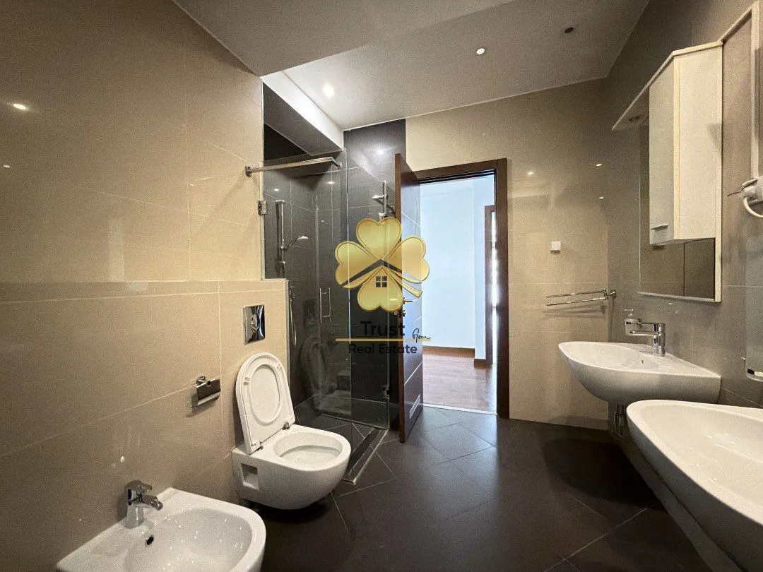 Moderne kupatilo sa tuš kabinom, dva umivaonika i WC šoljom.