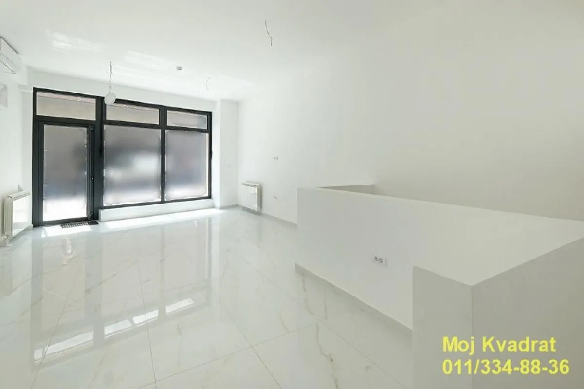 Empty bright room with white tiled flooring and large windows.