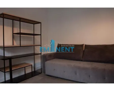 Living room with a comfortable sofa and an open bookshelf. - image 9