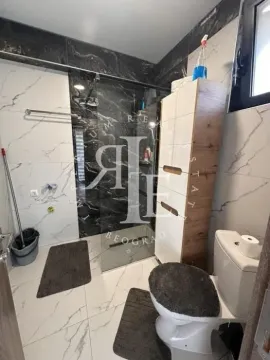 Modern bathroom with a walk-in shower and white marble-patterned ceramic tiles. - image 22