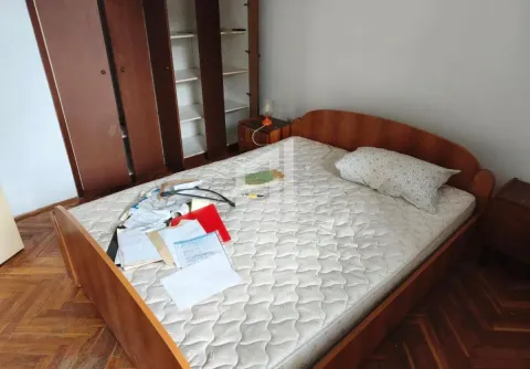 Bedroom with a wooden bed, wardrobe, and parquet flooring. - image 3
