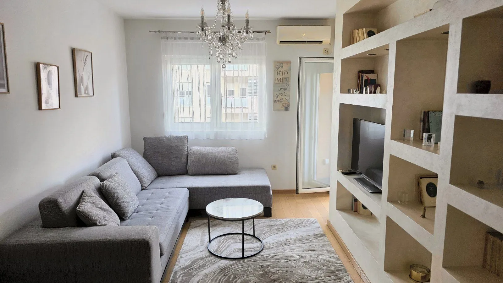 Living room with a sectional sofa, coffee table, and built-in TV shelving.