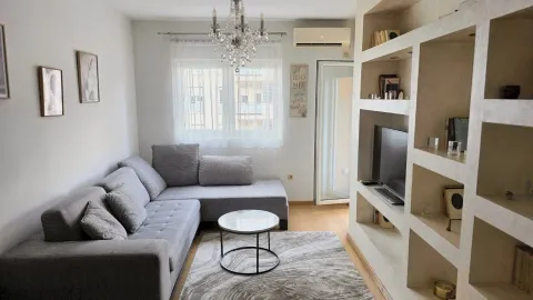 Living room with a sectional sofa, coffee table, and built-in TV shelving. - image 6