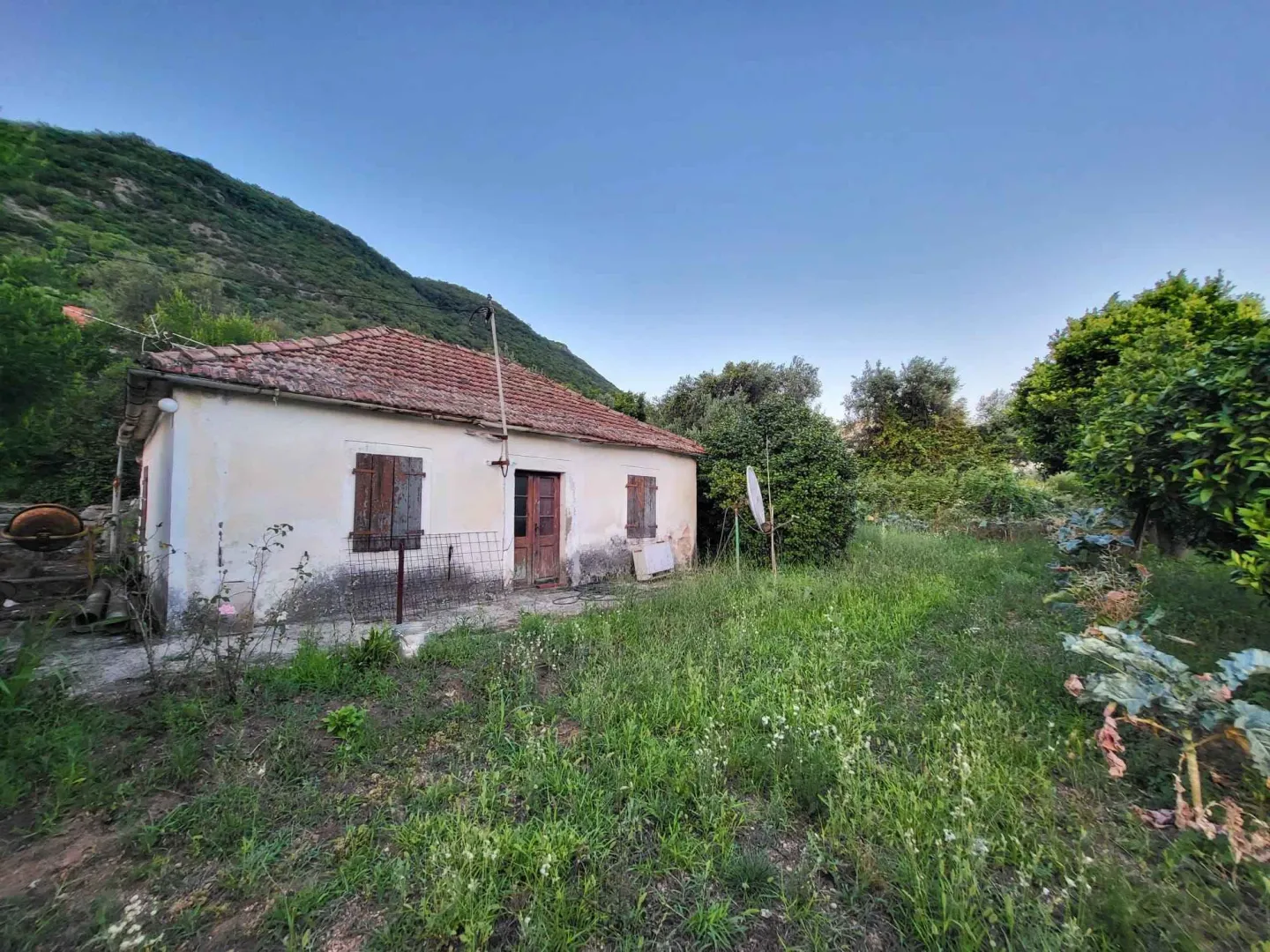 Pogled na staru kuću sa dvorištem u prizemlju.