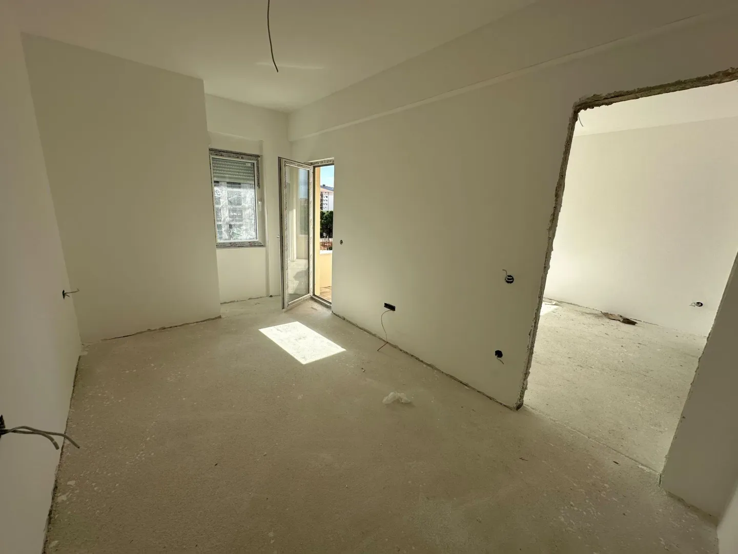 Unfurnished room under construction with an open doorway and access to the terrace.