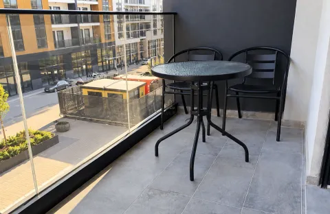 Namješten balkon sa okruglim stolom i dvije stolice i staklenom ogradom. - image 6