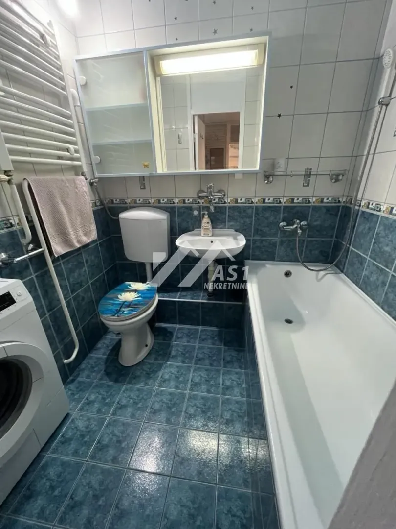 Kupatilo opremljeno kadom, umivaonikom, WC šoljom i veš mašinom.