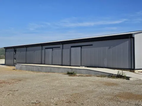 Exterior view of a modern industrial building or warehouse with a concrete ramp. - image 3