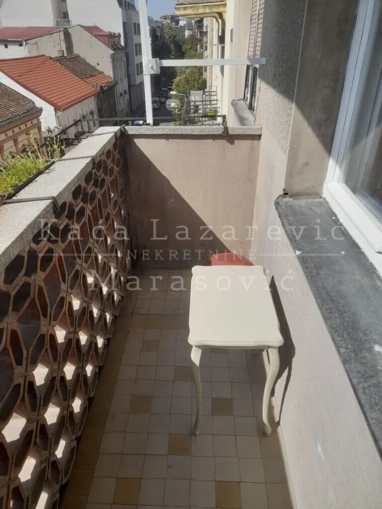 Manji balkon sa stočićem i pogledom na ulicu.