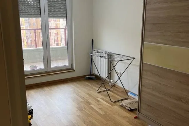 Manja soba sa drvenim podom, garderoberom i izlazom na terasu.