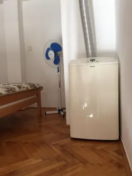 Dio spavaće sobe sa pokretnom klimom i parketom na podu. - image 12