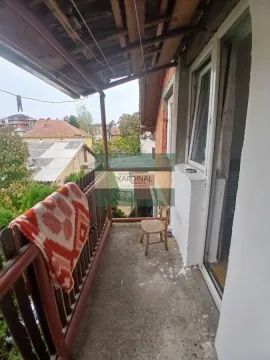 Natkriveni balkon sa pogledom na okolno naselje i drvenom ogradom. - image 21
