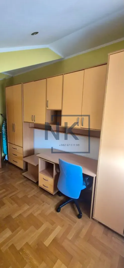 Furnished children's room with a desk, wardrobes, and a bed.