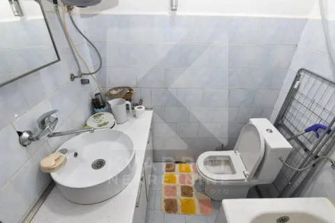 Smaller bathroom with a washbasin, toilet bowl and blue wall tiles. - image 11