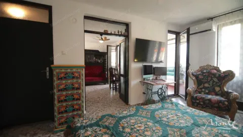Namještena spavaća soba sa krevetom, foteljom i pogledom na terasu. - image 3