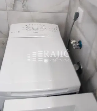 Bathroom with a washing machine and tiling. - image 10