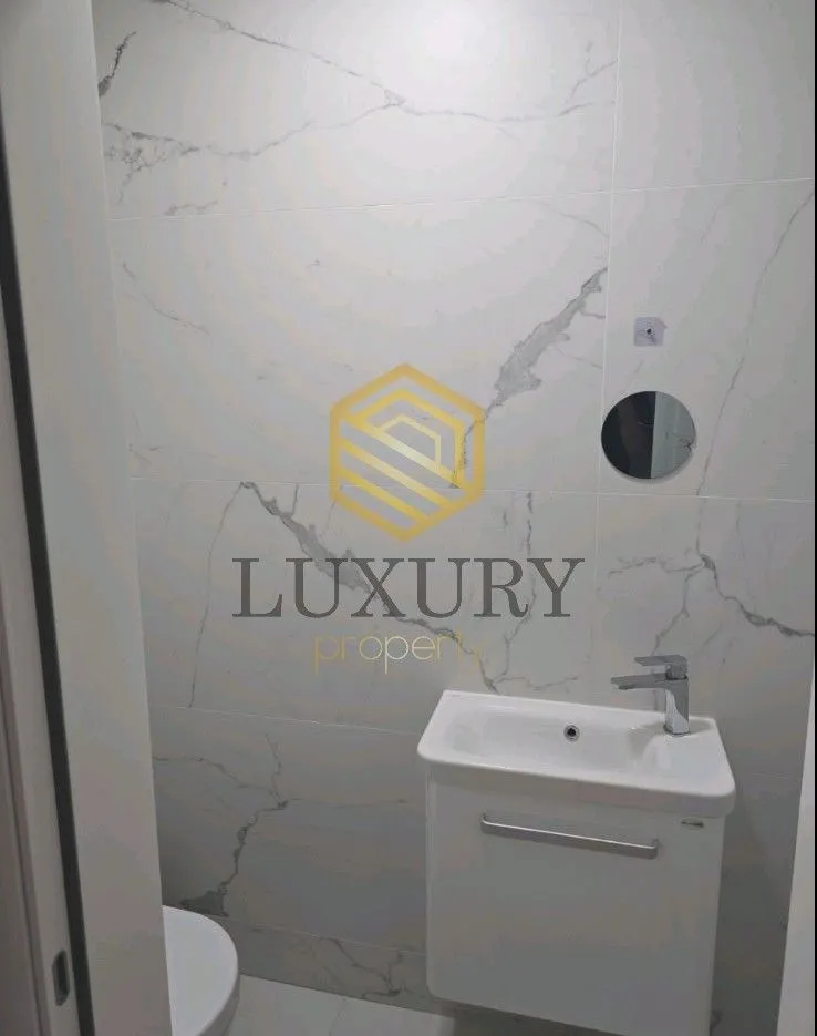 Small bathroom with white tiles and a washbasin.