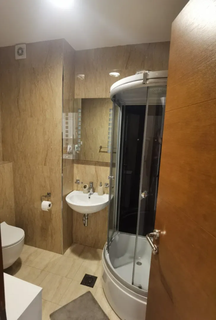Modernly equipped bathroom with a shower cabin and sink.