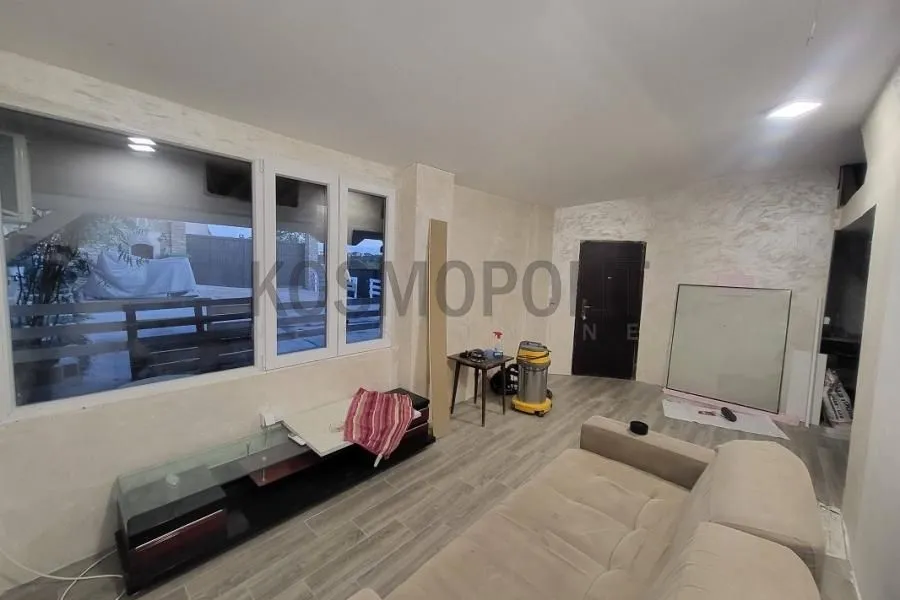 Living room with a sofa and large windows on the ground floor of the house.