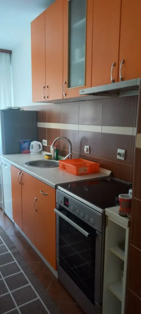 Functional kitchen featuring orange cabinets and a built-in stove.