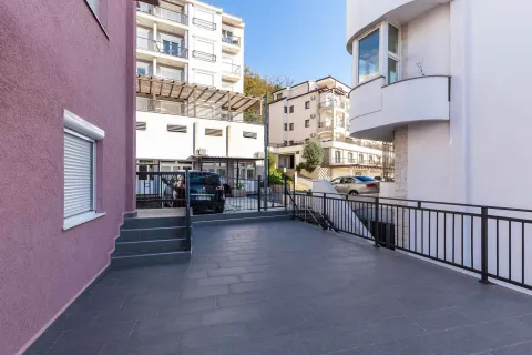 Popločano dvorište ispred stambene zgrade sa metalnom ogradom. - image 10