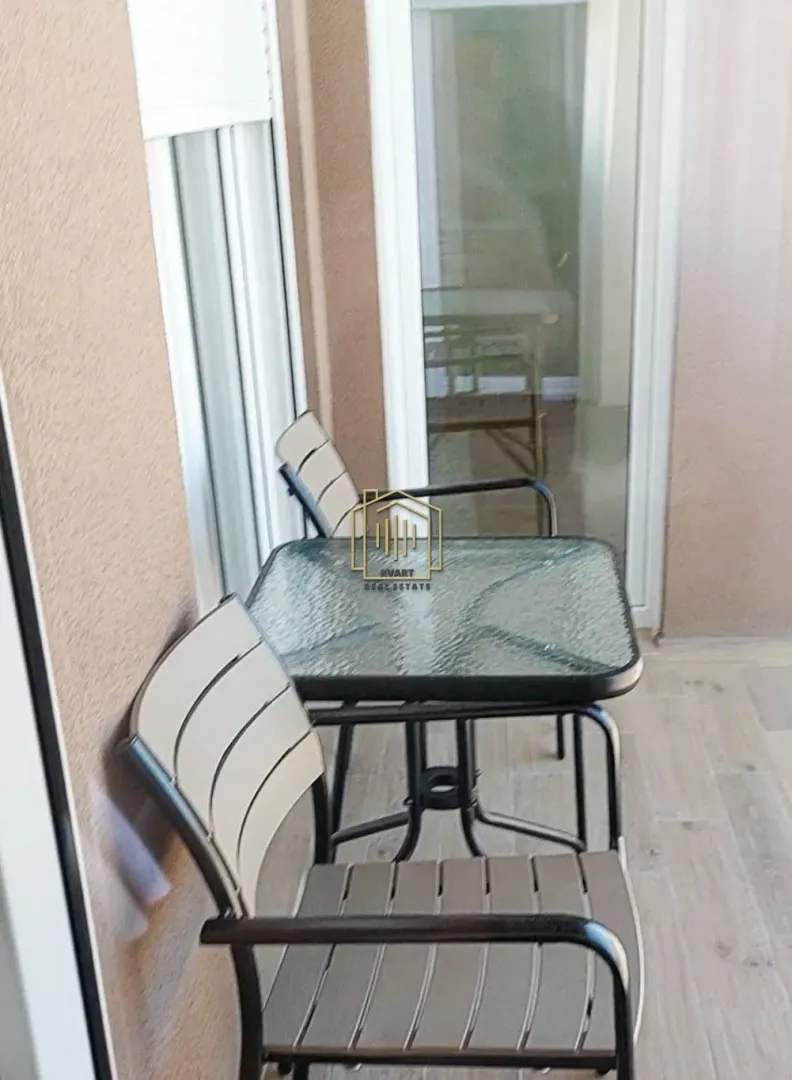 Manja terasa sa garniturom za sjedenje i staklenim stolom.