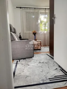 View from the hallway into the living room with a sofa and a window. - image 3