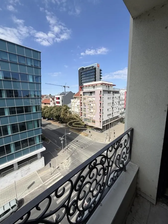 Pogled sa balkona na gradsku ulicu i okolne zgrade.