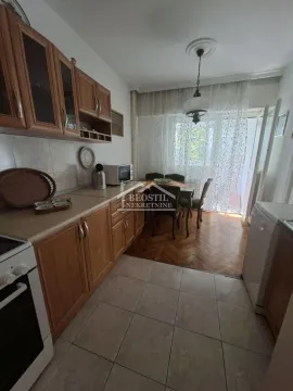 Kitchen with wooden cabinetry and a dining table. - image 3