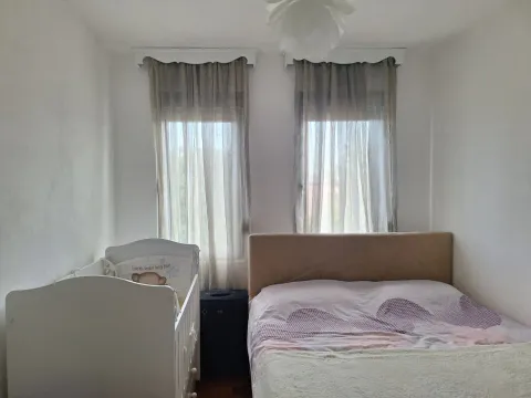 Spavaća soba sa bračnim krevetom i dječijim krevetcem pored prozora. - image 7