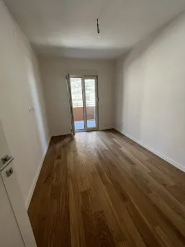 Empty, bright room with wooden flooring and balcony access. - image 3