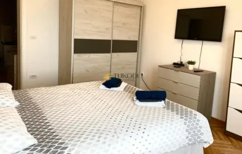 Furnished bedroom with a large double bed, wardrobe, and television. - image 15